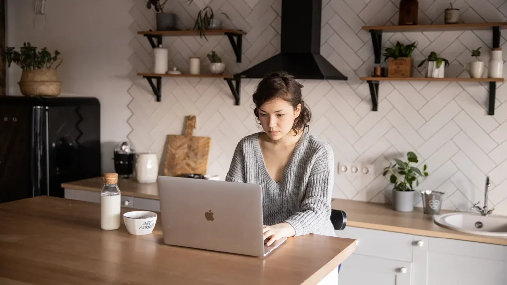 Why you should buy.uk domain names Women working on macbook deciding Why she should buy.uk domain name